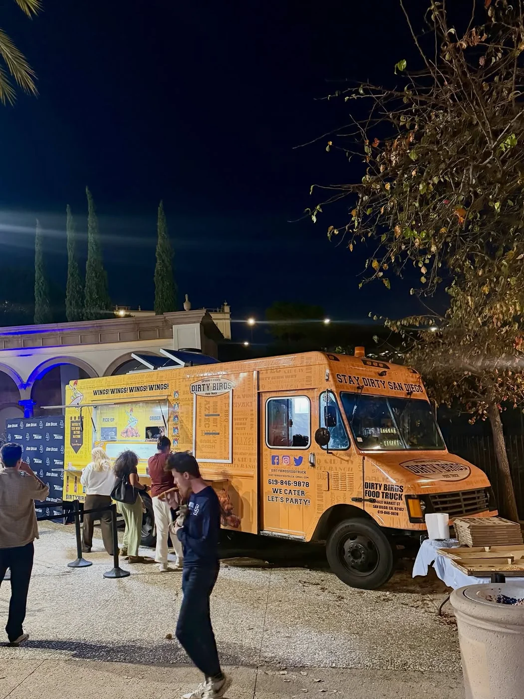 The orange Dirty Birds food truck lit up at night